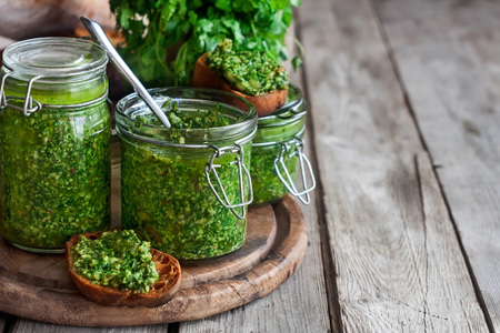 Homemade cilantro pesto in jars on wooden backgroundの写真素材