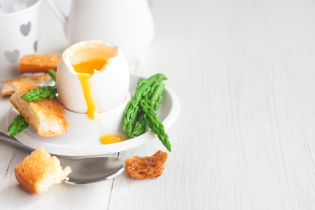 Soft boiled eggs with asparagus and toast soldiers. Copy space background.の写真素材