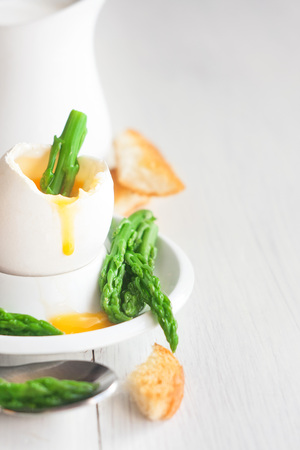 Soft boiled eggs with asparagus and toast soldiers. Copy space background.の写真素材