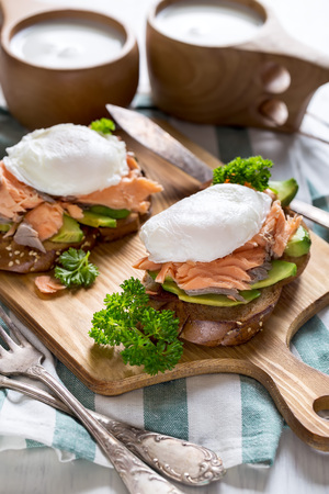 Eggs benedict, scandinavian style - with avocado and poached salmonの写真素材