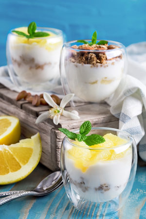 Yogurt with granola, almonds and grapefruit slices on old wooden backgroundの写真素材