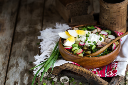 Russian traditional cold soup okroshka with potato, ham, cucmebers, eggs, radish, spring onion and kvass. Copyspace background.の写真素材