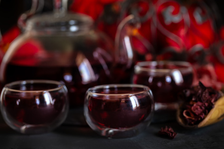 Herbal hibiscus tea carcade with red hibiscus flowers. Dark mood photo.の写真素材