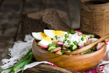 Russian traditional cold soup okroshka with potato, ham, cucmebers, eggs, radish, spring onion and kvass. Copyspace background.の写真素材