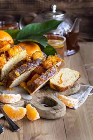 Glazed orange cake with tangerine jam topping and tea with lemonの写真素材