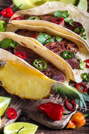 Traditional mexican street food - beef tongue tacos with ananas salsa and guacamoleの写真素材