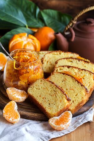 Glazed orange cake with tangerine jam topping and tea with lemonの写真素材