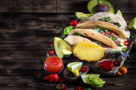 Traditional mexican street food - beef tongue tacos with ananas salsa and guacamole. Copy space background.の写真素材