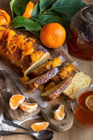 Glazed orange cake with tangerine jam topping and tea with lemonの写真素材