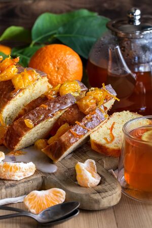 Glazed orange cake with tangerine jam topping and tea with lemonの写真素材