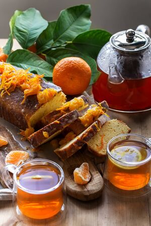 Glazed orange cake with tangerine jam topping and tea with lemonの写真素材