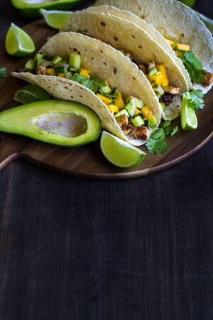 Homemade chicken tacos with mango, ananas and cucumber salsa. Copyspace background.の写真素材