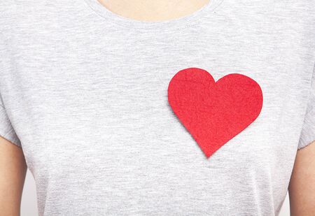 The woman is carrying a red heart on her chest.