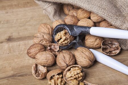 Walnuts on a wooden table and in a sack. Healthy food and snack.