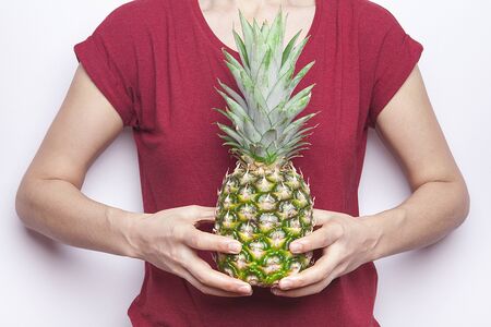 Ripe pineapple woman's in hand isolated on white background.の写真素材