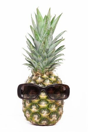 Ripe pineapple with sunglasses on a white backgroundの写真素材