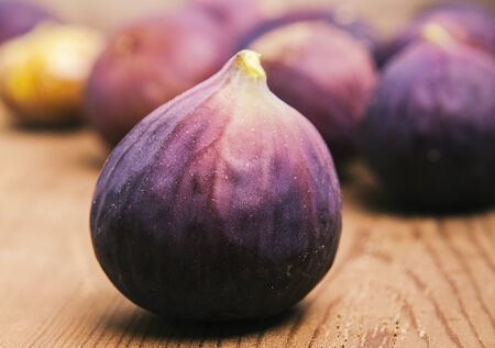 Fresh fruits, figs on the wooden background.