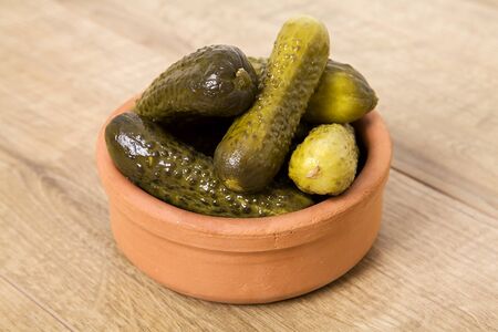 Marinated pickled cucumber isolated on wooden background.の写真素材