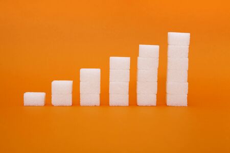 White sugar cube on orange background.の写真素材