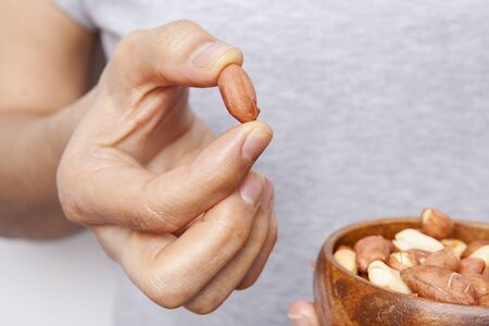 Woman's in hand peanut in a bowls.
