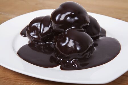 Triple Chocolate Profiteroles. Sweet Dessert on white plate.