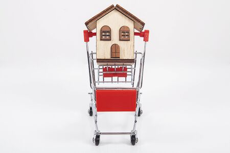 Real estate agent concept. House model inside shopping cart.の写真素材