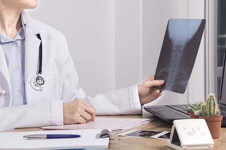 Female doctor examines the x-ray movie. Examination room in hospital. Medicine and healthcare...