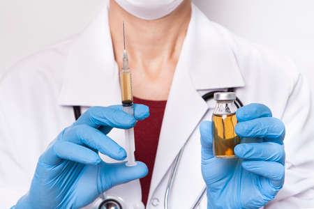 The doctor is holding medicine bottle and syringe.の写真素材