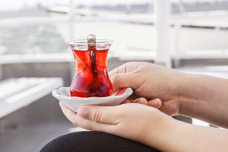 A cup of tea in woman's hands on a ship.の写真素材