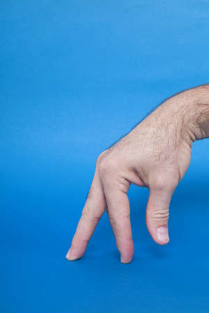 Man hand showing on blue background.の写真素材