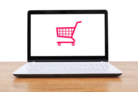 Computer and small toy shopping cart on display. Internet shopping concept.の写真素材