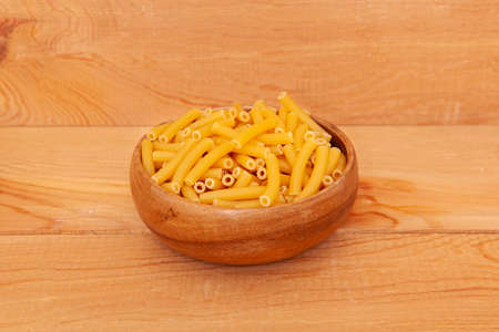 Uncooked cake in wooden bowl on wooden background.の写真素材