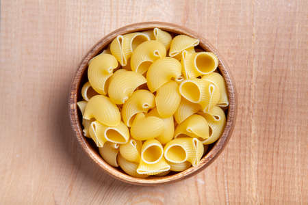 Uncooked cake in wooden bowl on wooden background. Ravioli cake.の写真素材