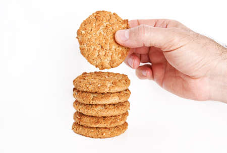 on a white background, in the man's hand; oatmeal, figs, hazelnuts, peanuts and sesame cookies....