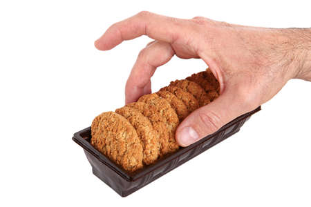 on a white background, in the man's hand; oatmeal, figs, hazelnuts, peanuts and sesame cookies....