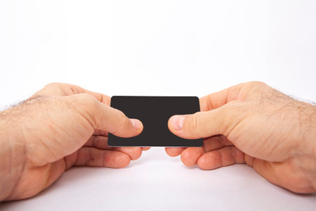 The man is holding a credit card in his hand.
