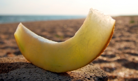 A slice of melon on the beachの写真素材