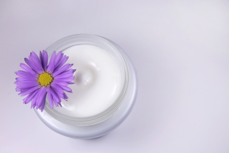 Cream jar and violet flowerの写真素材