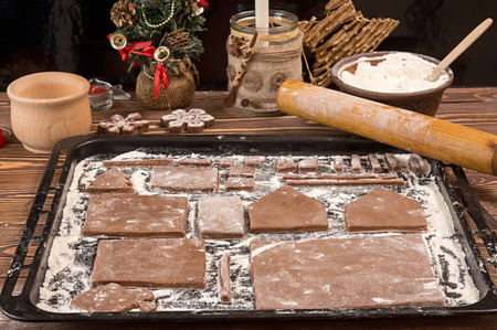 Preparation gingerbread house for Christmas celebration. Baking gingerbread cookies. Gingerbread...