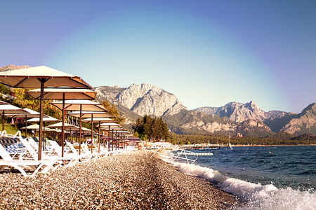 Sunshades and chaise lounges on beach. Turkey, Kemer. Beautiful view of mountains and seaの写真素材