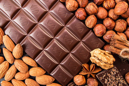 Chocolate pieces, filbert, chocolate shavings and walnuts over n dark background. の写真素材