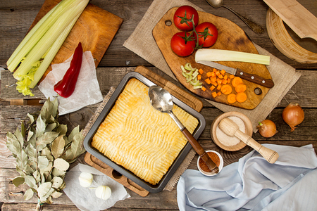 Shepherd's pie traditional english dish. Recipe with minced beef, lamb, carrot, onion, celery, mashed potato baked in casserole. Dinner table. Rustic style. Top viewの写真素材