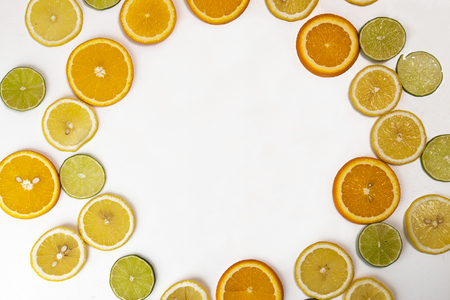 Flat lay still life with wreath from citrus: orange fruit; lime; lemon, lime on white background.の写真素材