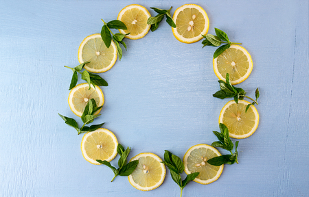 Flat lay round still life with mint and lemon on blue background. Pop art trend still lifeの写真素材