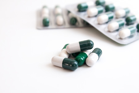 Heap of medicine tablets pills on white background. Healthcare or medicament addiction concept. Copy space.の写真素材