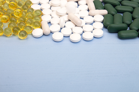 Pills background. Heap of assorted various medicine tablets and pills in blisters different colors on blue background. Healthcare or medicament addiction concept. Copy space. Top viewの写真素材