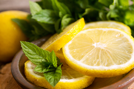 Mint and slices of lemon on old wooden background.の写真素材