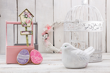 Happy Easter decoration for greeting card. Wooden bird, birdhouse, gingerbread Easter cookies in...