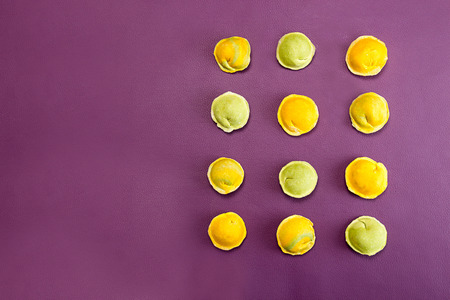 Homemade raw dumpling, traditional East European food before boiling. Trend ultraviolet color background. Top view. Copy space.の写真素材