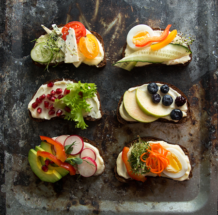 Healthy breakfast toasts with vegetables, fruits and microgreen on rusty background. Clean eating healthy food concept. Top view. Copy space.の写真素材